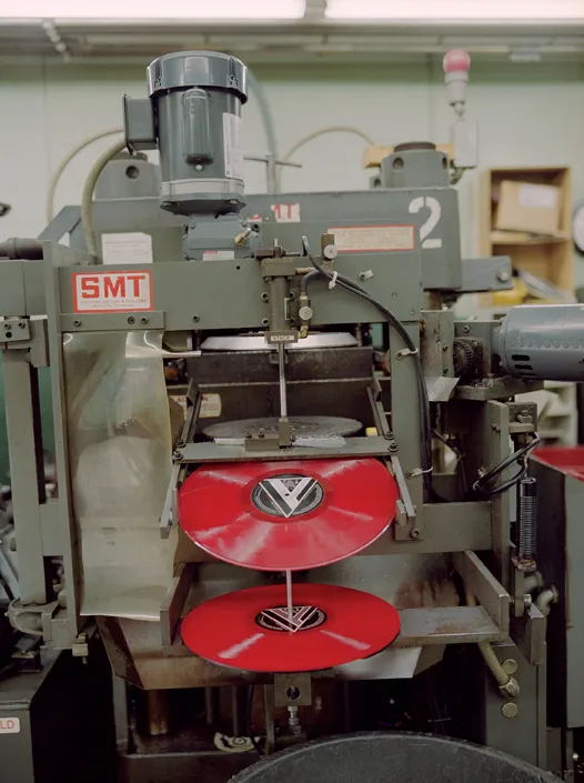 Vinyl record being pressed in a production machine
